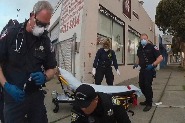 Desetine smrtnih slučajeva u SAD od ubrizgavanja sedativa ljudima pri hapšenju In this image from Richmond Police Department body-camera video, a paramedic, left, holds a syringe as he prepares to inject Ivan Gutzalenko, 47, with the sedative midazolam in Richmond, Calif., on March 10, 2021. When the paramedic returned three minutes after the injection, Gutzalenko lay motionless. He was declared dead at a hospital. An investigation by The Associated Press found that at least 16 people died in California in 2012-2021 following physical encounters with police during which medical personnel also injected them with a powerful sedative. (Richmond Police Department via AP)