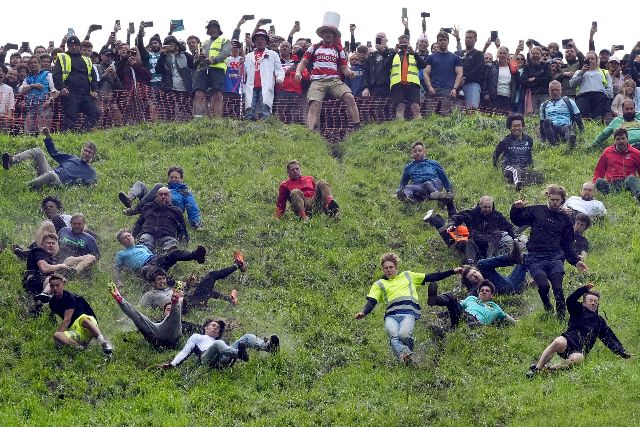 U Velikoj Britaniji se održavaju trke za sirom niz padinu Participants take part in the annual cheese rolling at Cooper's Hill in Brockworth, England, Monday, May 27, 2024. The traditional event attracts people from around the globe who come to chase a 7lb Double Gloucester cheese down the steep Coopers Hill. (Jacob King/PA via AP)