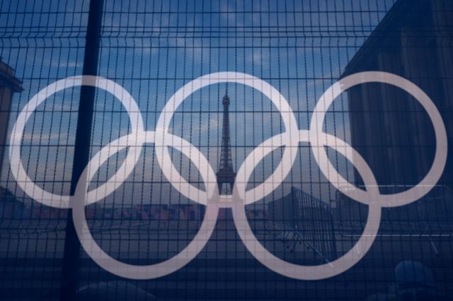 U Parizu kontra-ceremonija za najsiromašnije, 24 sata pre svečanosti otvaranja OI The Eiffel Tower is seen behind the Olympic rings, at the Trocadero plaza Thursday, July 18, 2024 in Paris. (AP Photo/David Goldman)