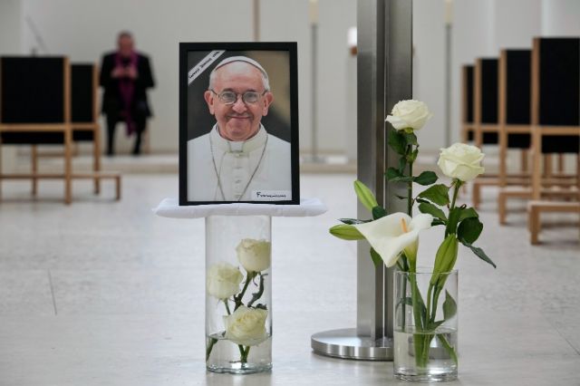 Vatikan: Uzrok smrti pape Franje je moždani udar A photo of the late Pope Francis stands with flowers at the Saint Hedwig's Cathedral, in Berlin, Germany, Monday, April 21, 2025. (AP Photo/Ebrahim Noroozi)