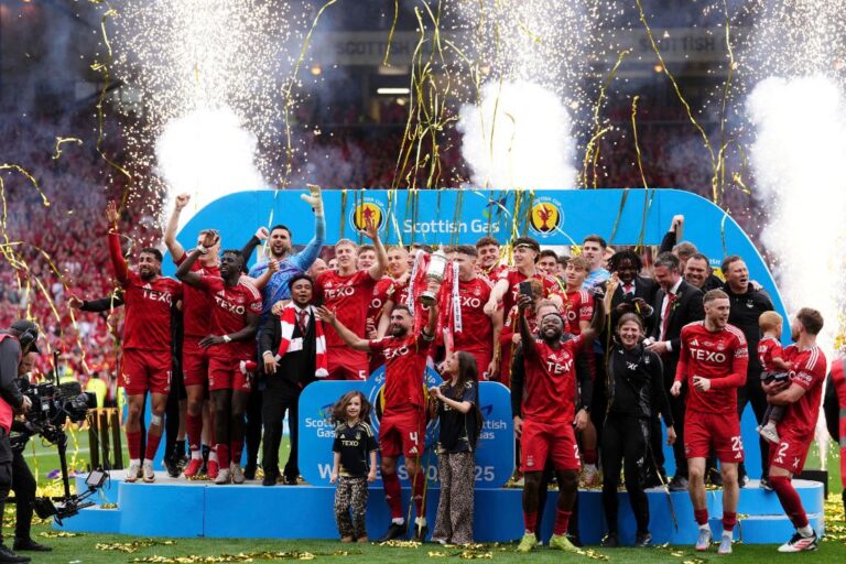 Aberdeen's Graeme Shinnie, centre, lifts the trophy as the team members celebrate after the Scottish Cup final soccer match between Aberdeen and Celtic at Hampden Park in Glasgow, Scotland, Saturday, May 24, 2025. (Andrew Milligan/PA via AP)