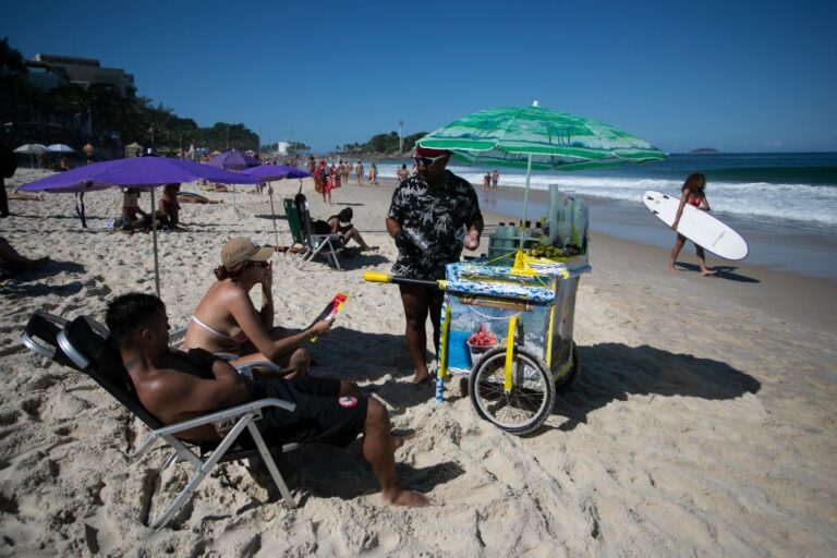 A vendor offers smoothies to beachgoers on Ipanema Beach in Rio de Janeiro, Sunday, May 25, 2025.(AP Photo/Bruna Prado)