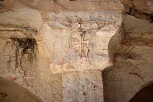 A sign of the cross is etched into the top of a stone column at a Byzantine underground tomb complex, believed to be over 1,500 years old, uncovered by a contractor during reconstruction of a war-damaged house in Maarat al-Numan, Idlib suburb, Syria, on Friday, May 30, 2025. (AP Photo/Omar Albam)