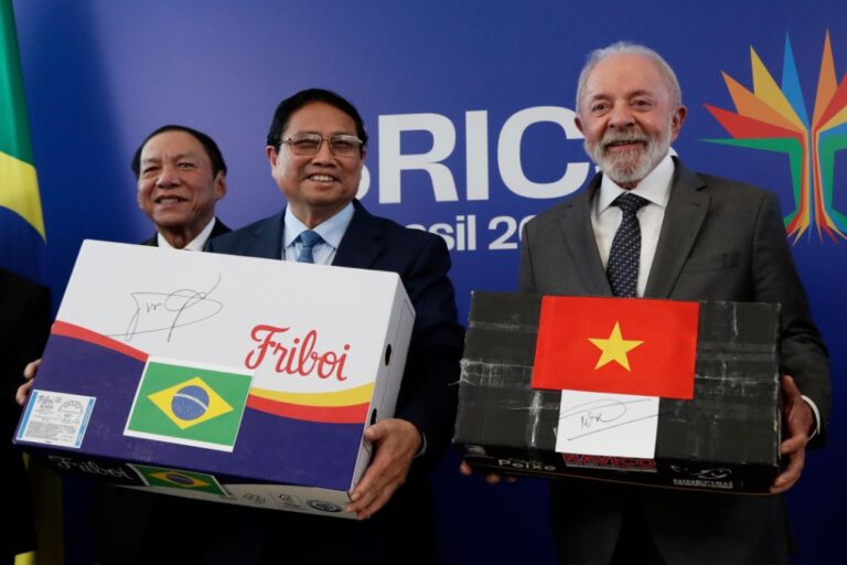 Brazilian President Luiz Inacio Lula da Silva, right, holding an empty box representing Vietnamese fish, and Vietnam's Prime Minister Pham Minh Chinh, holding an empty box representing Brazilian beef, pose for photos after signing a bilateral trade agreement, ahead of the upcoming 17th annual BRICS summit in Rio de Janeiro, Saturday, July 5, 2025. (AP Photo/Bruna Prado)