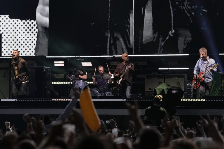 Liam Gallagher, left, and Noel Gallagher, right, from the band Oasis perform during their reunion concert on Friday, July 4, 2025, in Cardiff. (Photo by Scott A Garfitt/Invision/AP)