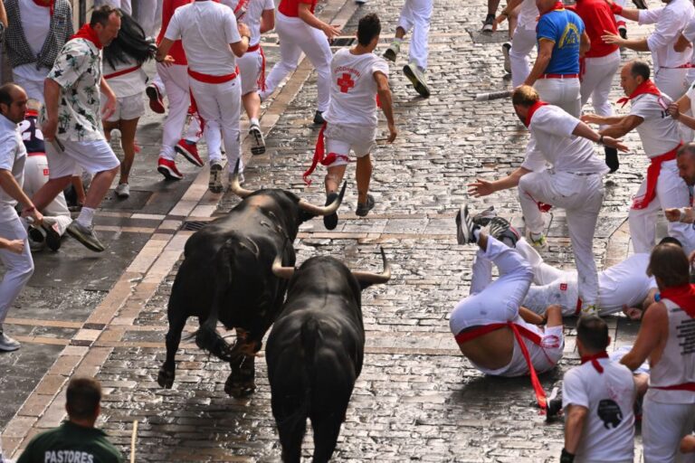 Revelers run with bulls from Fuente Ymbro ranch during the first day of the running of the bulls at the San FermÌn fiestas in Pamplona, Spain, Monday, July 7, 2025. (AP Photo/Miguel Oses)