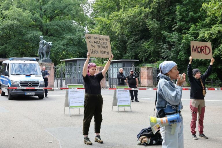 Demonstrators stand with protest signs in front of the Nuremberg Zoo in Nuremberg, Germany, Tuesday, July 29, 2025. Slogan reads 'we won't remain silence until all animals can live in freedom'. (Daniel Loeb/dpa via AP)